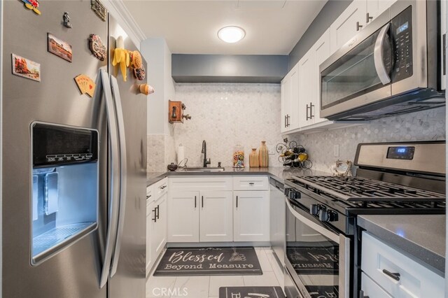 kitchen with white cabinets, decorative backsplash, sink, and stainless steel appliances