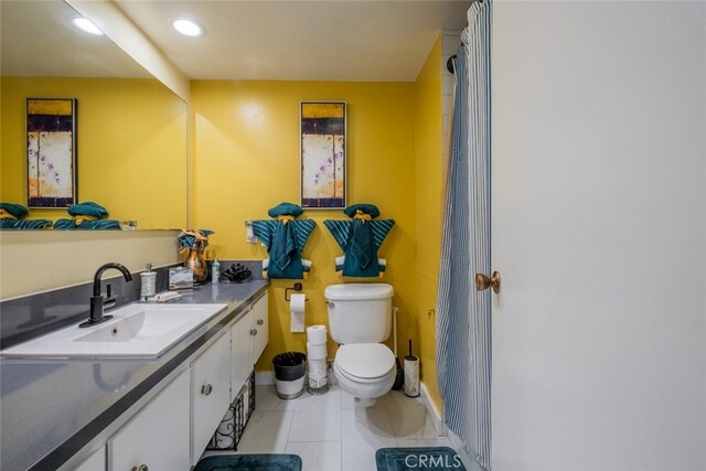 bathroom with tile patterned flooring, vanity, and toilet