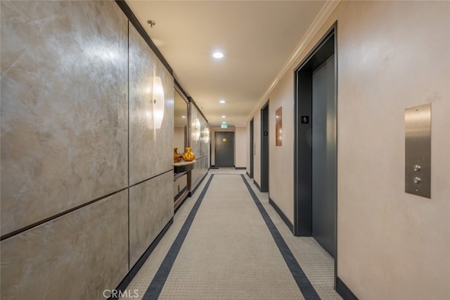 hall with crown molding, elevator, and light carpet