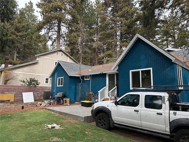 exterior space featuring central AC unit and a front yard