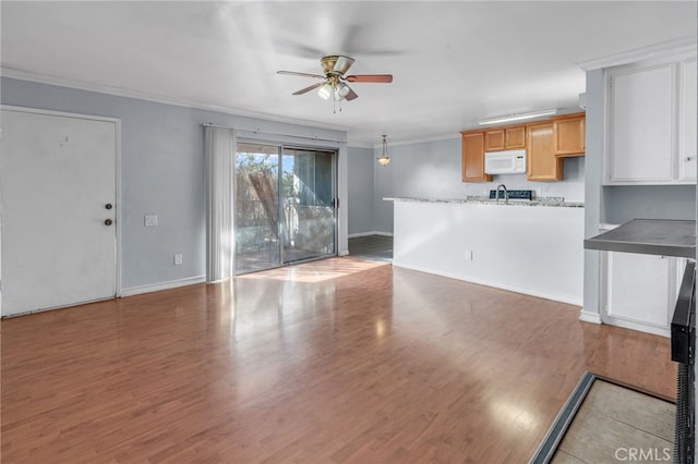 unfurnished living room featuring ceiling fan, crown molding, and hardwood / wood-style flooring