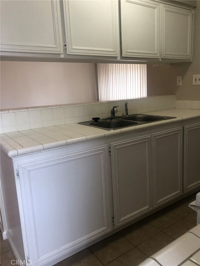 kitchen featuring tile countertops, sink, and dark tile patterned flooring