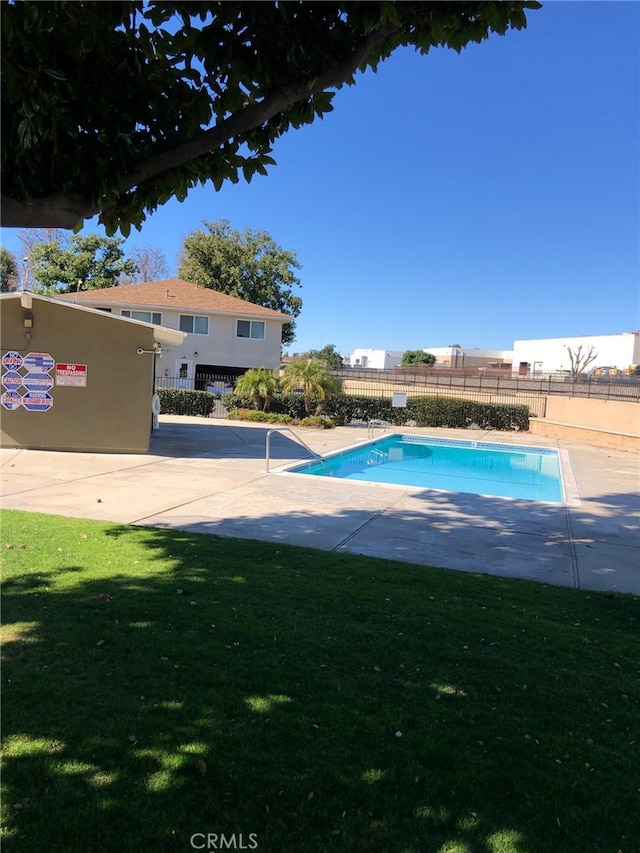 view of pool featuring a yard and a patio