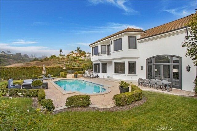 1 Moss Lndg, Laguna Niguel, CA 92677 - rear view of property featuring stucco siding, a lawn, a patio area, an outdoor pool, and a tile roof