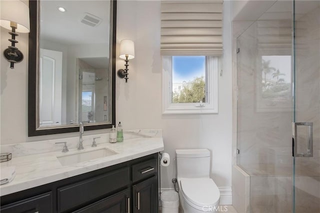 bathroom with toilet, vanity, and walk in shower