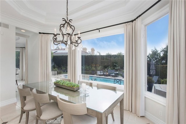 dining room with a tray ceiling, light tile patterned floors, a notable chandelier, and ornamental molding