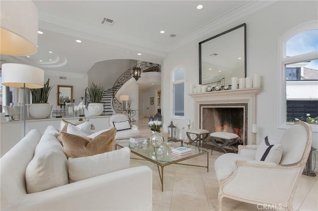 living room featuring crown molding, a fireplace, and light tile patterned flooring