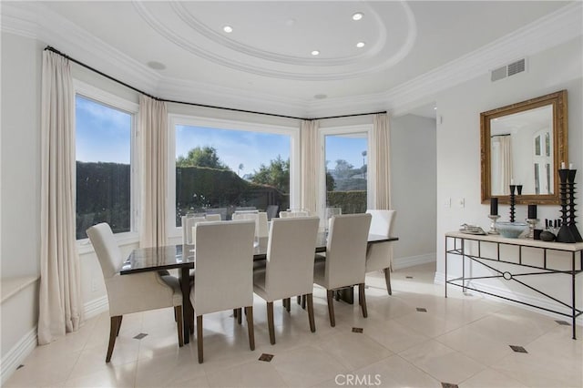 tiled dining room with a tray ceiling, a wealth of natural light, and crown molding