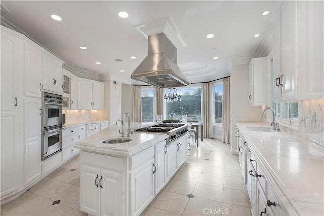 1 Moss Lndg, Laguna Niguel, CA 92677 - kitchen with stainless steel appliances, white cabinets, backsplash, island exhaust hood, and an island with sink
