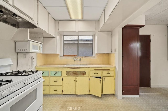 kitchen with white cabinets, white appliances, backsplash, and sink