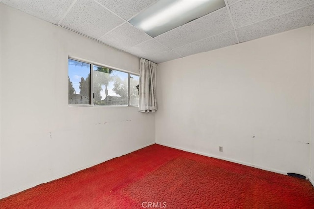 carpeted spare room with a paneled ceiling