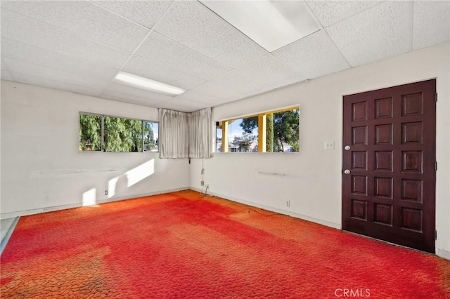 unfurnished room with carpet and a paneled ceiling