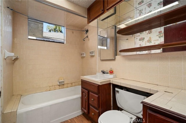 full bathroom featuring tasteful backsplash, hardwood / wood-style floors, toilet, vanity, and tiled shower / bath