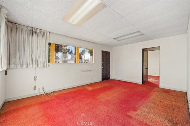 empty room featuring a paneled ceiling and carpet floors