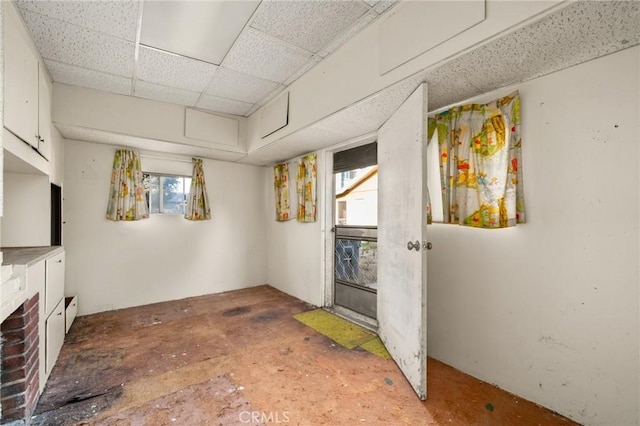 interior space with a paneled ceiling and a healthy amount of sunlight