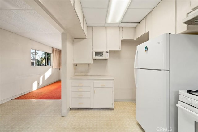 kitchen featuring white cabinets and white appliances