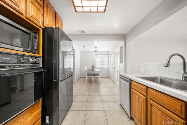 kitchen featuring black appliances, light tile patterned flooring, sink, and an inviting chandelier