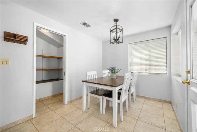 dining area featuring a notable chandelier and light tile patterned floors