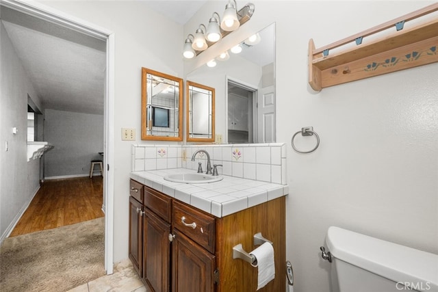 bathroom featuring hardwood / wood-style floors, vanity, toilet, and tasteful backsplash