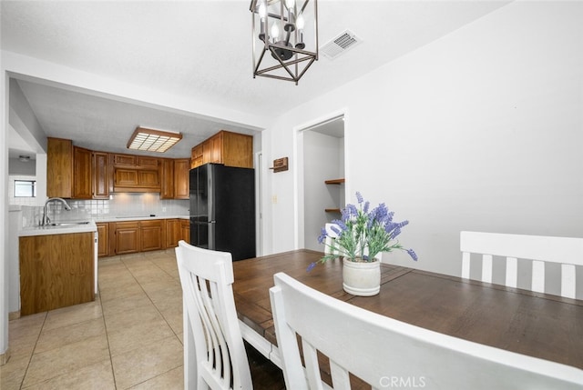 dining room featuring light tile patterned flooring, sink, and a chandelier