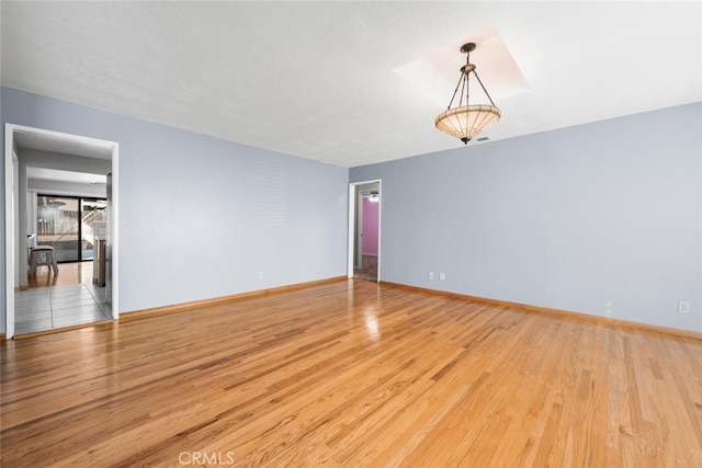 unfurnished room featuring a textured ceiling and light hardwood / wood-style floors