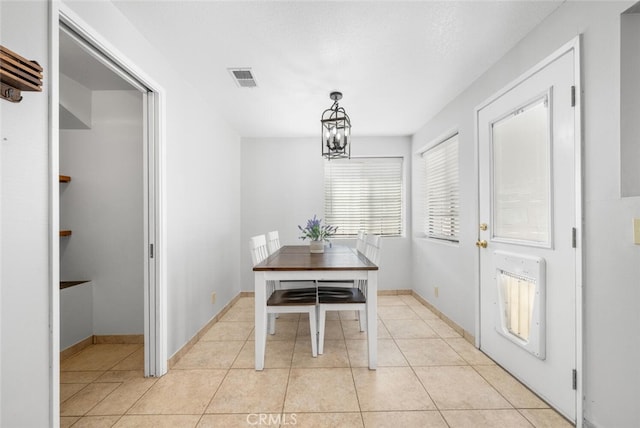 tiled dining space with an inviting chandelier