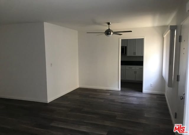 unfurnished room featuring dark hardwood / wood-style floors and ceiling fan