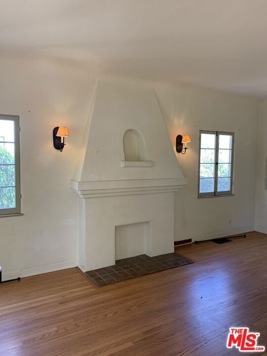 unfurnished living room featuring hardwood / wood-style flooring and a wealth of natural light