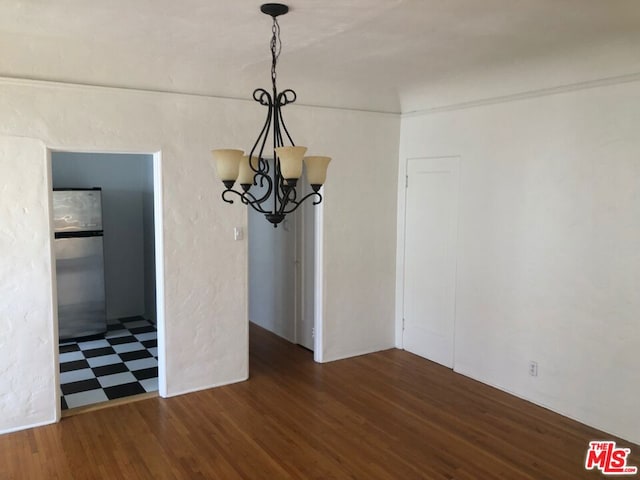 unfurnished dining area featuring a chandelier and dark hardwood / wood-style floors