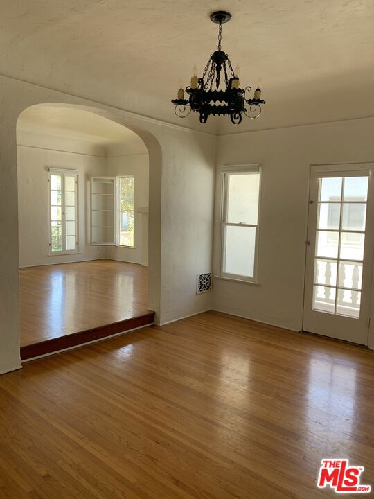 unfurnished dining area featuring hardwood / wood-style floors and a notable chandelier