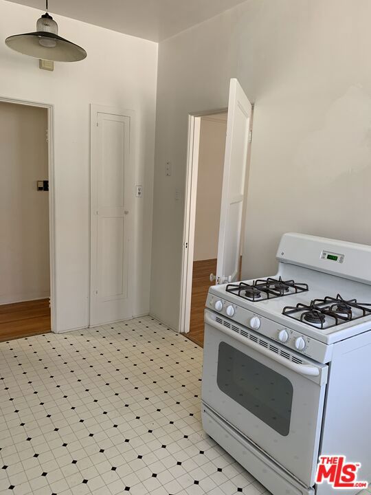 kitchen with light hardwood / wood-style floors and white range with gas cooktop