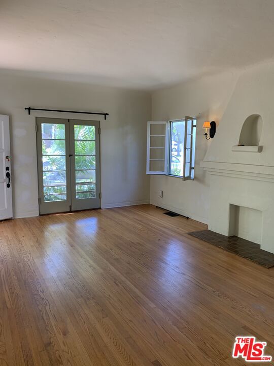 unfurnished living room featuring a wealth of natural light and hardwood / wood-style floors