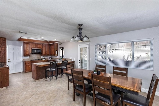 dining area featuring a notable chandelier and a textured ceiling