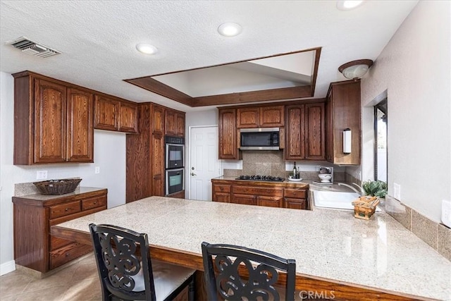 kitchen featuring sink, backsplash, light tile patterned floors, kitchen peninsula, and stainless steel appliances