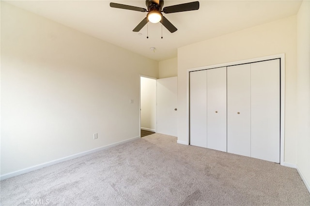 unfurnished bedroom featuring ceiling fan, light carpet, and a closet