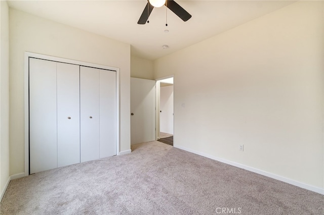 unfurnished bedroom featuring ceiling fan, a closet, and light colored carpet