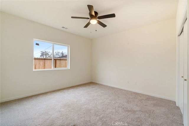 carpeted spare room with ceiling fan