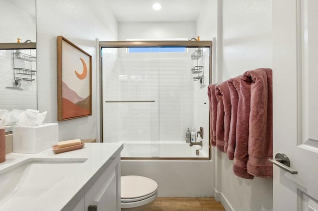 full bathroom featuring toilet, vanity, and bath / shower combo with glass door