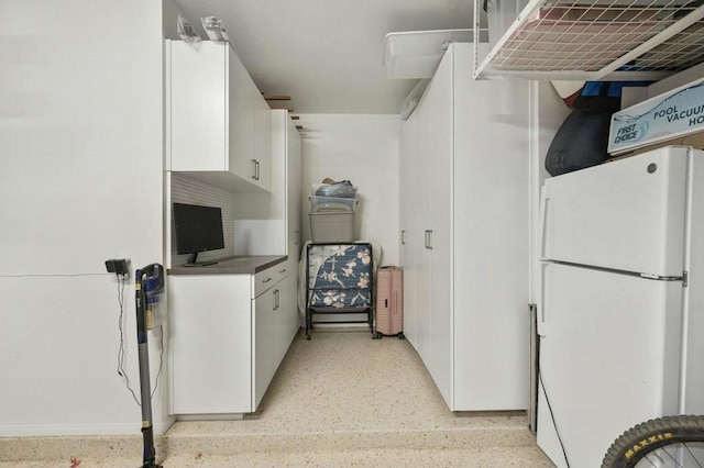 kitchen featuring white refrigerator and white cabinets