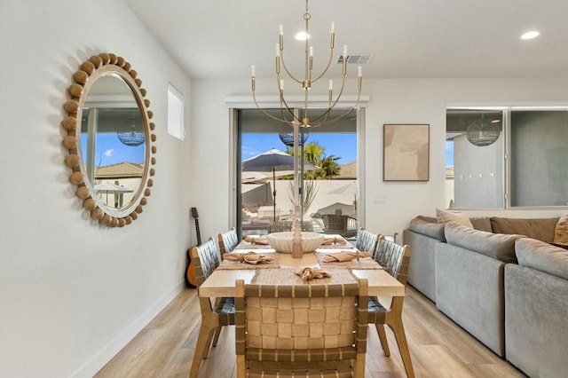 dining room with light wood-type flooring and a notable chandelier