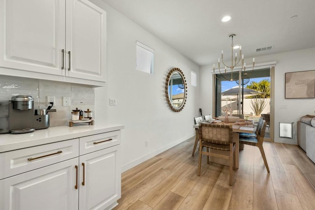 dining area featuring an inviting chandelier and light hardwood / wood-style flooring