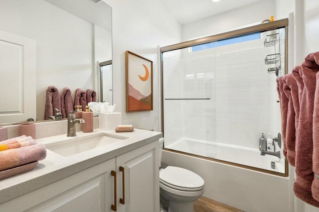 full bathroom featuring toilet, bath / shower combo with glass door, and vanity