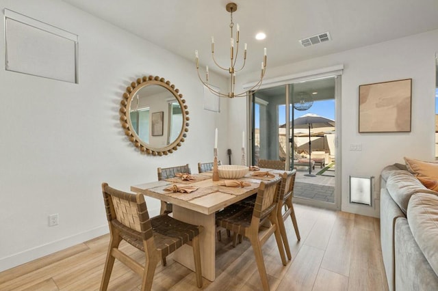 dining area featuring light wood-type flooring and an inviting chandelier