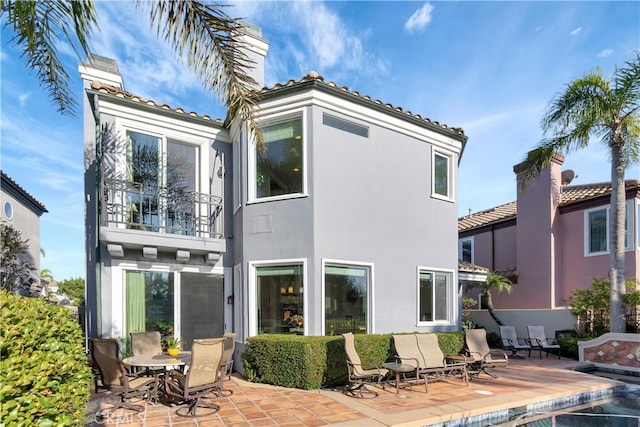 back of house featuring a balcony and a patio