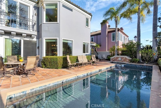 rear view of house with a balcony and a patio