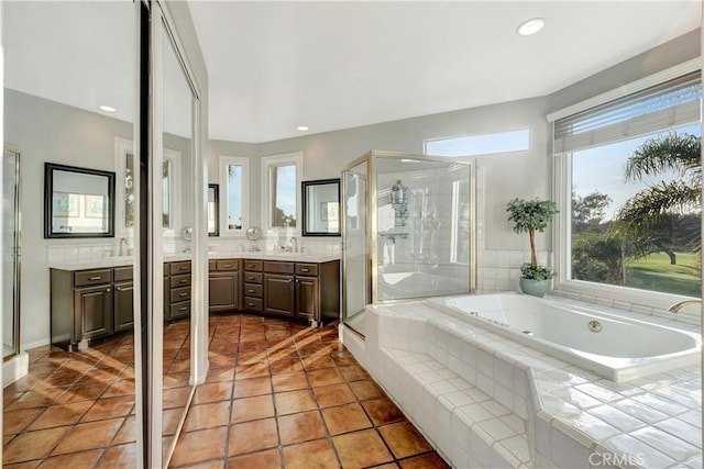 bathroom featuring tile patterned floors, vanity, independent shower and bath, and a wealth of natural light