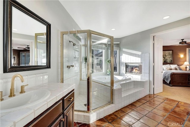 bathroom with plus walk in shower, tile patterned flooring, vanity, and ceiling fan