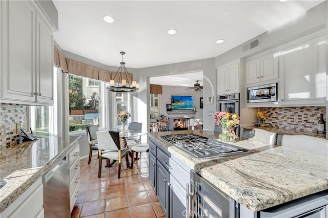 kitchen with tasteful backsplash, wine cooler, white cabinetry, and stainless steel appliances