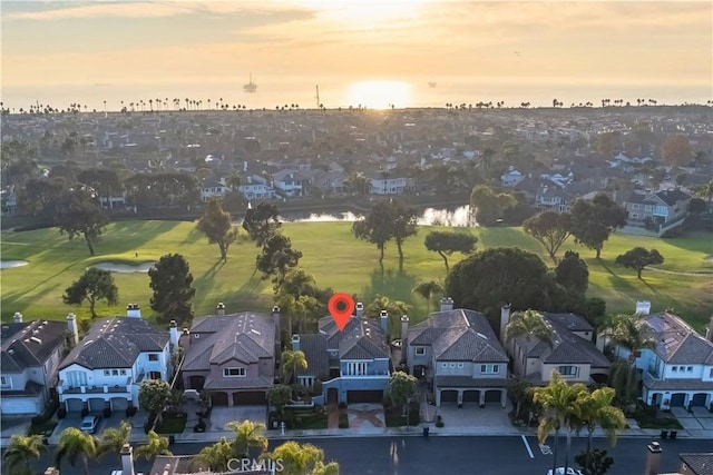 aerial view at dusk featuring a water view