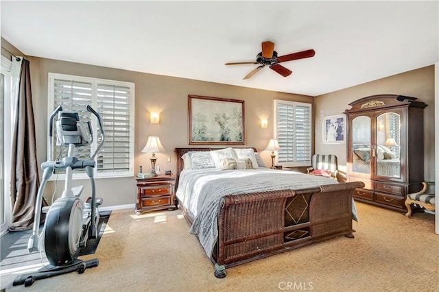 bedroom featuring multiple windows, light colored carpet, and ceiling fan